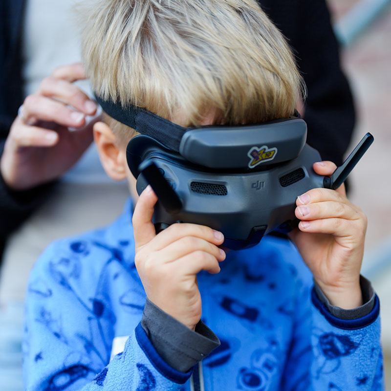 Kind mit FPV-Brille beim Drohnenflug